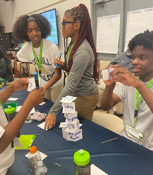 students building card tower with sports terminology notecards