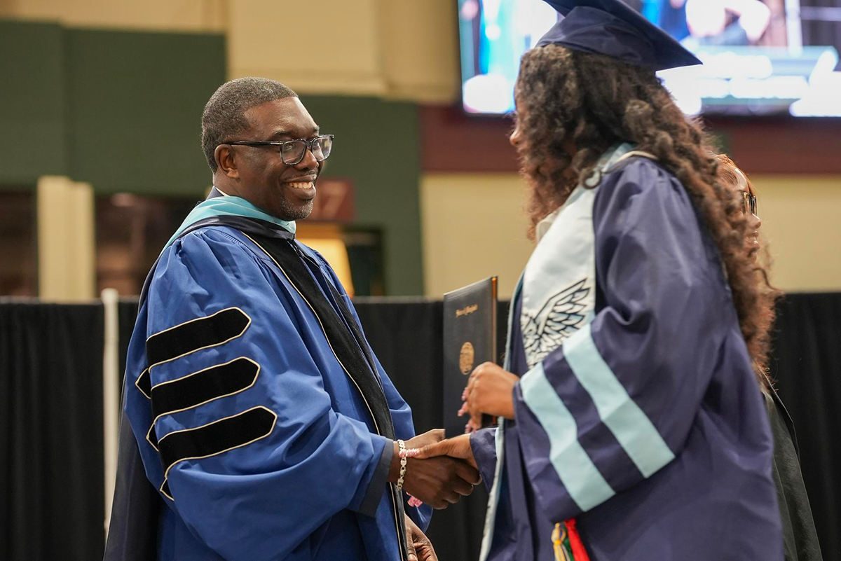 Dr. Joseph shaking AHS graduates hand