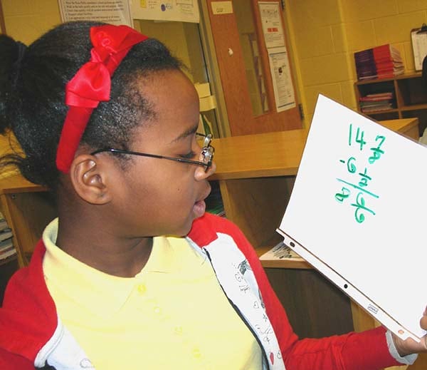 math-student-completing-math-calculation-on-whiteboard.jpg